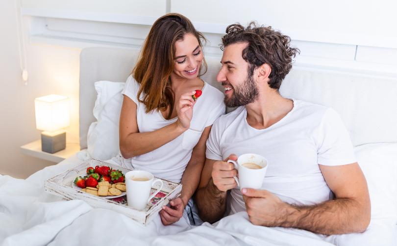 Junges Paar frühstückt im Bett - Romantischer Tag zu zweit