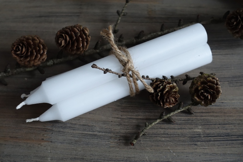 weiße Stabkerzen, Zweige und Zapfen - basteln mit Kerzen 