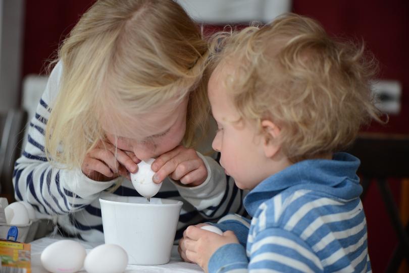 2 kleine Kinder pusten Eier aus - Das Osterfest mit Kindern