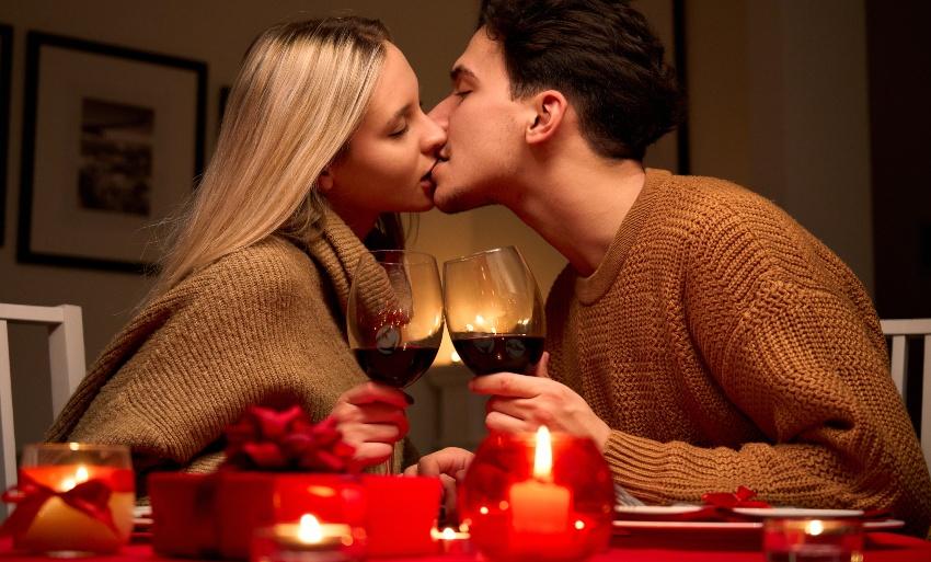 Paar küsst sich an romantisch gedecktem Tisch - Romantische Valentinsdeko