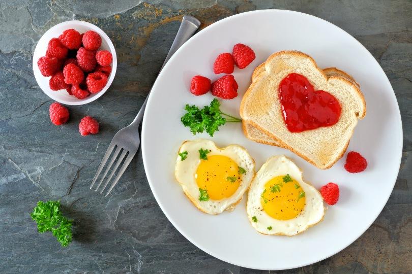 Muttertagsfrühstück mit Toast und Ei in Herzform
