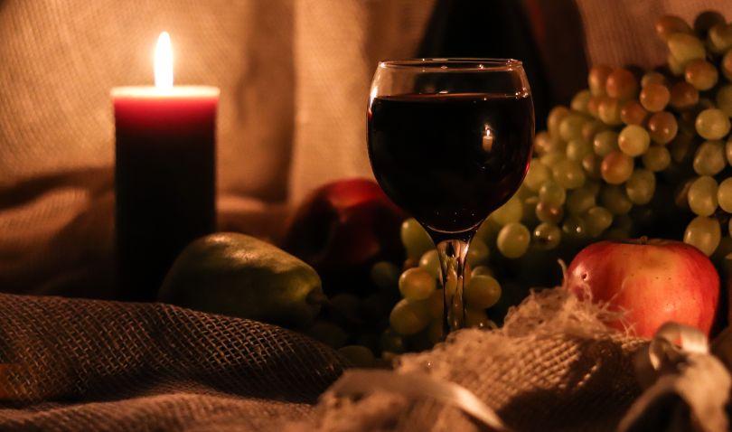 Wein, Reben, Apfel, Kerze - Symbolbild für Erntedankfest