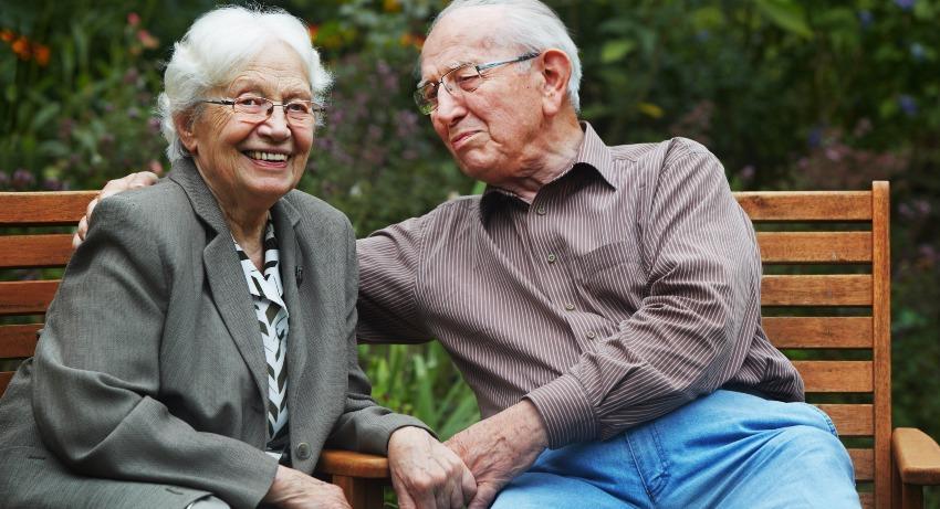 Altes Paar sitzt im Garten 